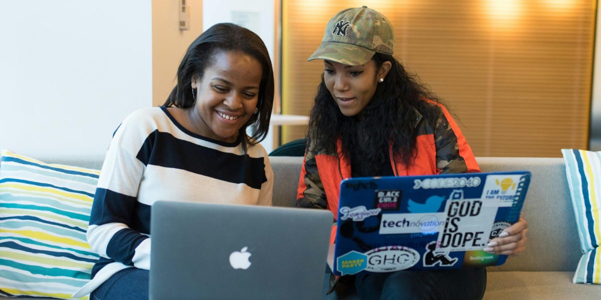 Two Women Holding Laptop