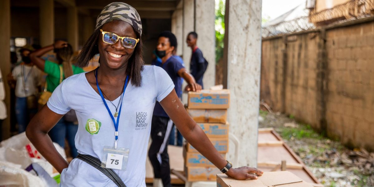 A Happy Volunteer Leaning on a Box